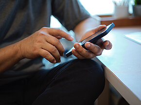 Cropped,Shot,Of,Man,Using,His,Smartphone,In,Comfortable,Workspace