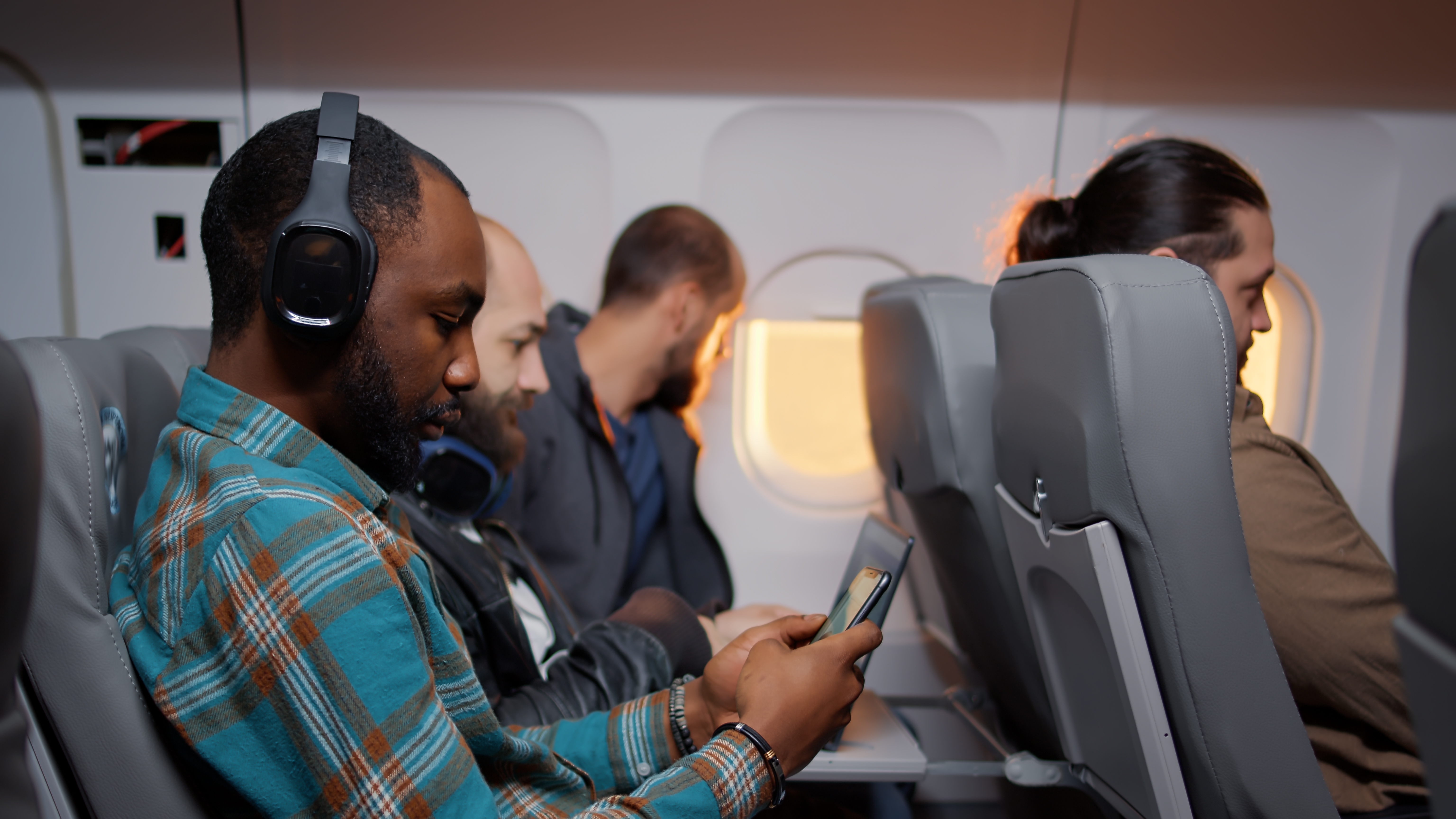 2178260949 Male,Tourist,Using,Smartphone,On,Airplane,Flight,During,Sunset,,Browsing