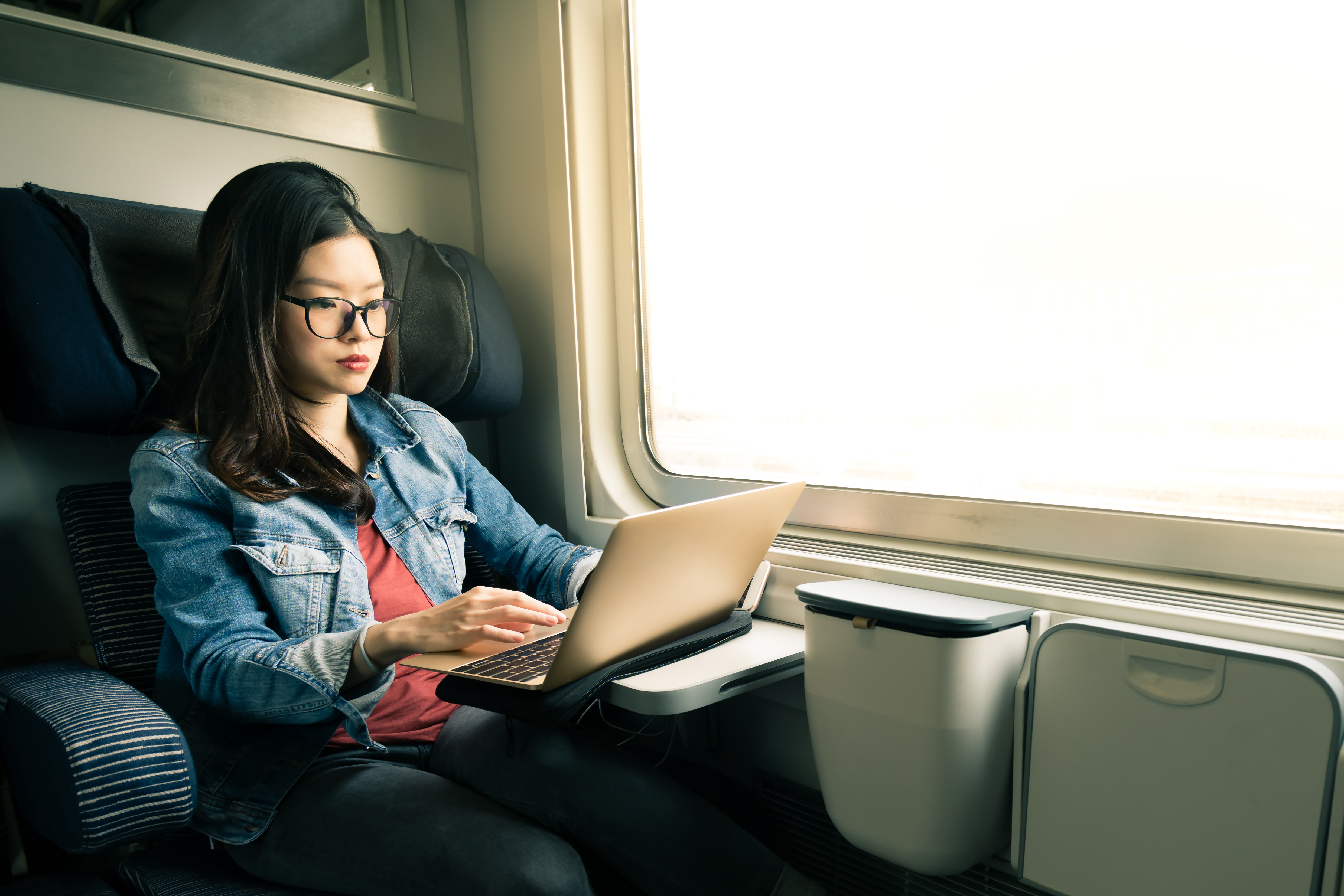 424353676 Asian,Woman,Work,On,Laptop,On,Train,,Business,Travel,Concept,